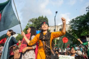 Young woman in a protest, holding a Bangladeshi flag