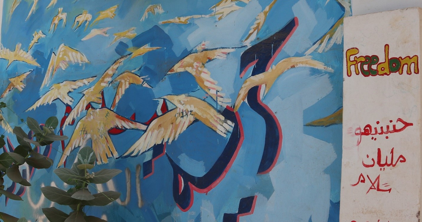 Mural in Khartoom with images of doves and the word "Freedom"
