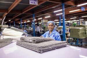 Woman smiles at camera in a factory